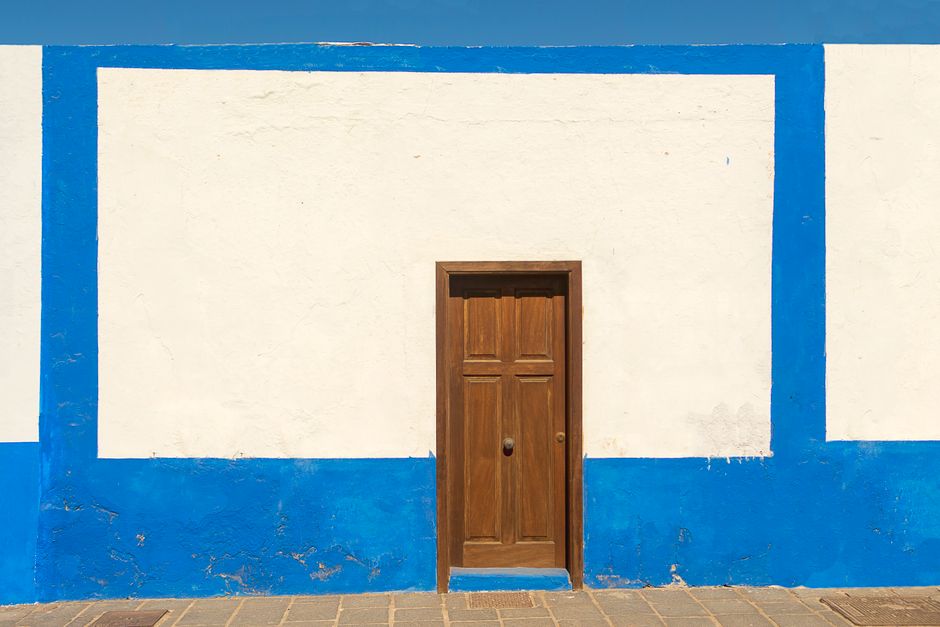 Painted house exterior with trim and a door in daylight