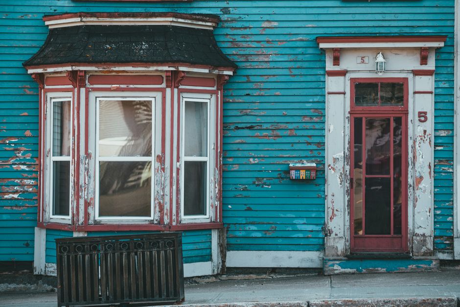 House exterior with a painted wall and a freshly coloured door