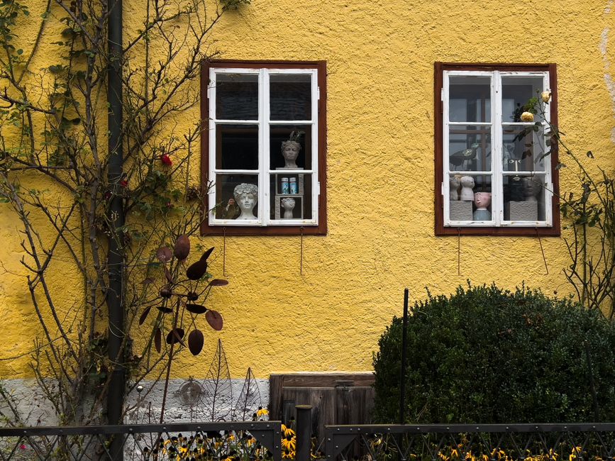 Painted house front with window trim and a wooden door