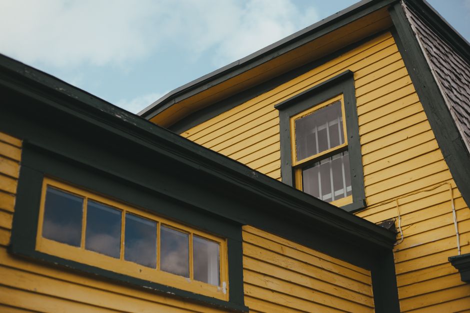 Painted house exterior with trim and a door in daylight