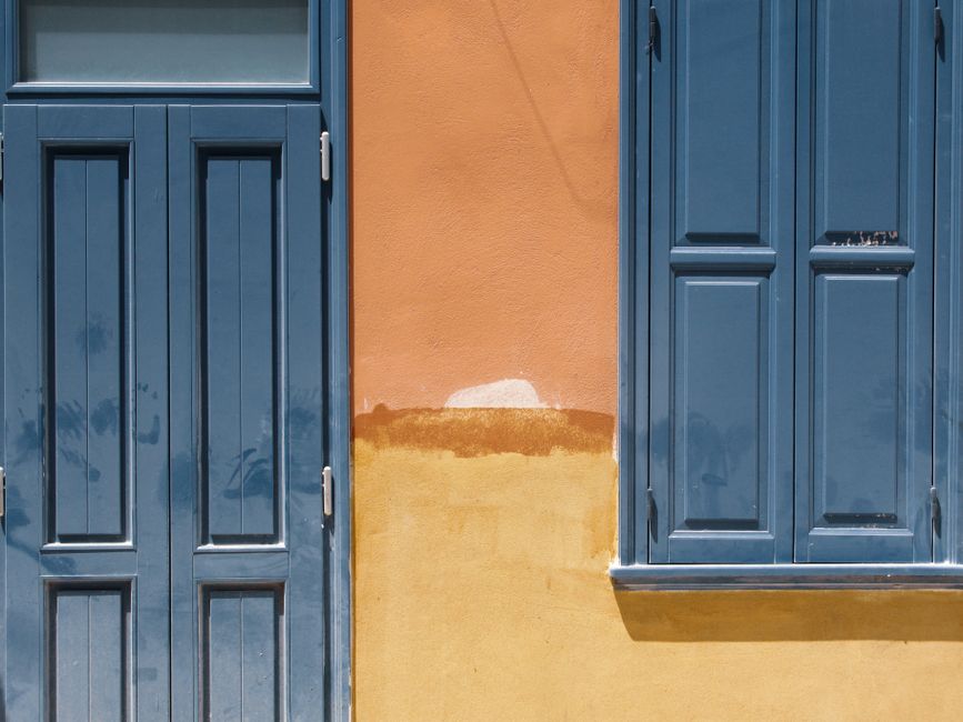Painted house exterior with trim and a door in daylight